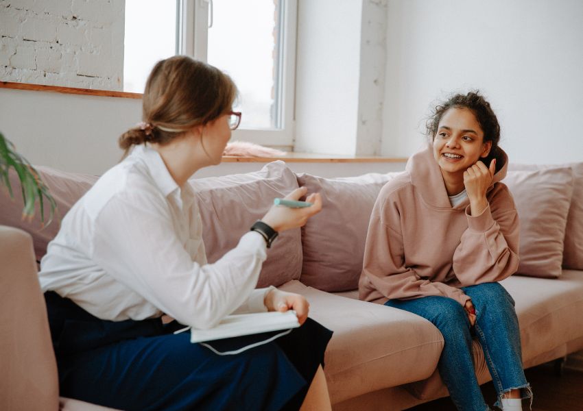 person-talking-with-another-on-sofa